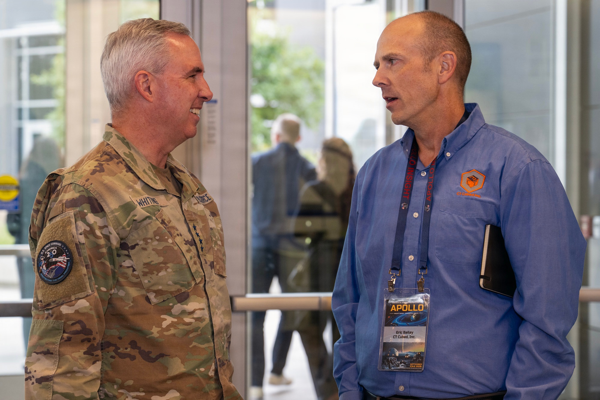 Gen. Stephen Whiting, commander of U.S. Space Command, talks with Eric Bailey of CT Cubed at the Apollo Insight wargame in Colorado Springs. Bailey wears a CT Cubed shirt and an event badge reading APOLLO.